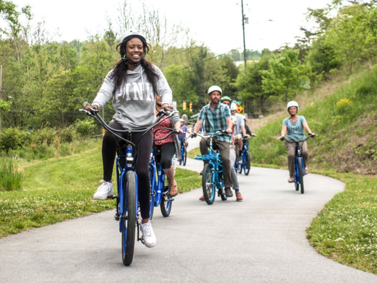 Group of people riding bikes on their custom group bicycle tour of Asheville Greenways