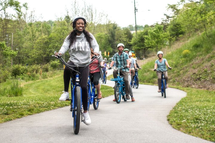 Group of people riding bikes on their custom group bicycle tour of Asheville Greenways