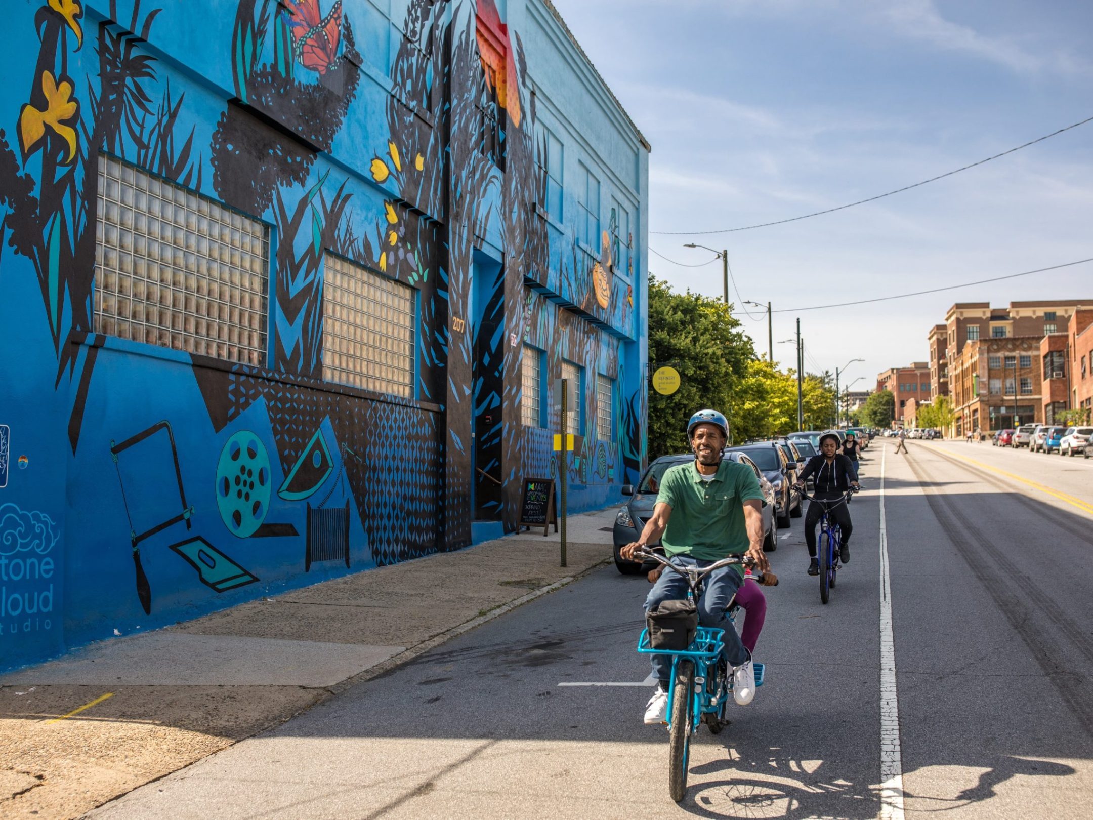 Group of people on a custom bike tour of Asheville, NC passing by a graffiti art mural wall
