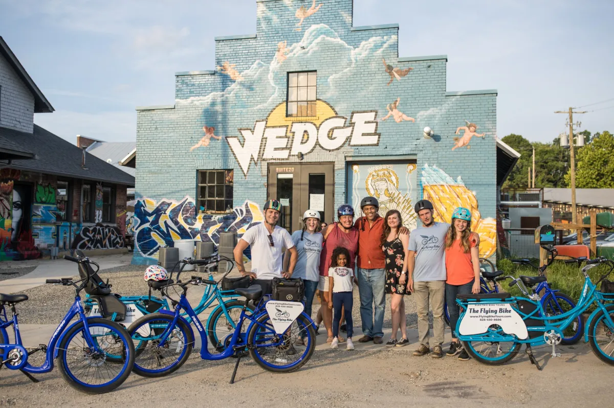 Group of people smiling and posing during their group bicycle tour in Asheville