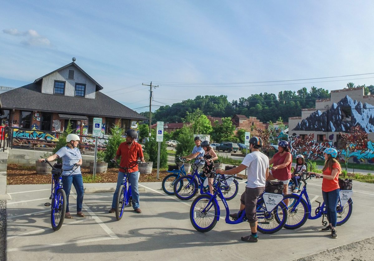 River_Arts_District_Foundation.jpg A group gathered in the River Arts District of Asheville on an electric bike tour surrounded by buildings covered in graffiti artwork.