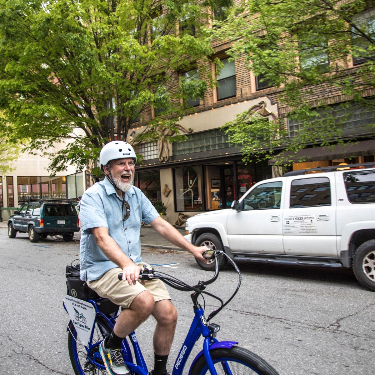 A happy man taking a bicycle tour of a city